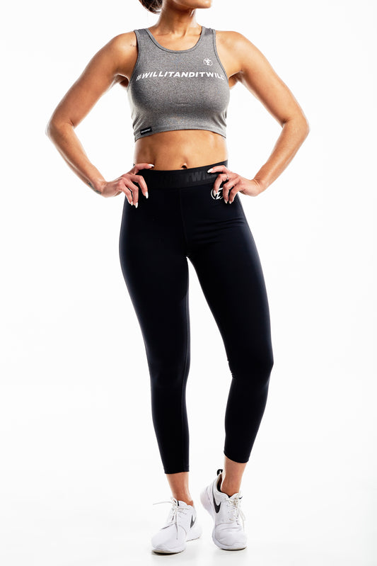 Woman in gray crop top and black leggings, athletic wear.