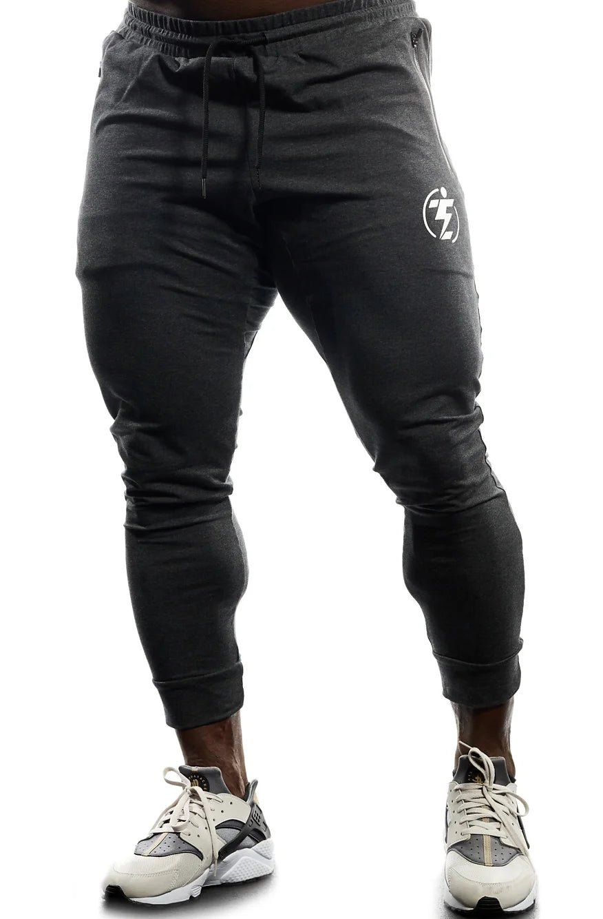 Dark grey slim-fit joggers with drawstring and white logo, shown on model.