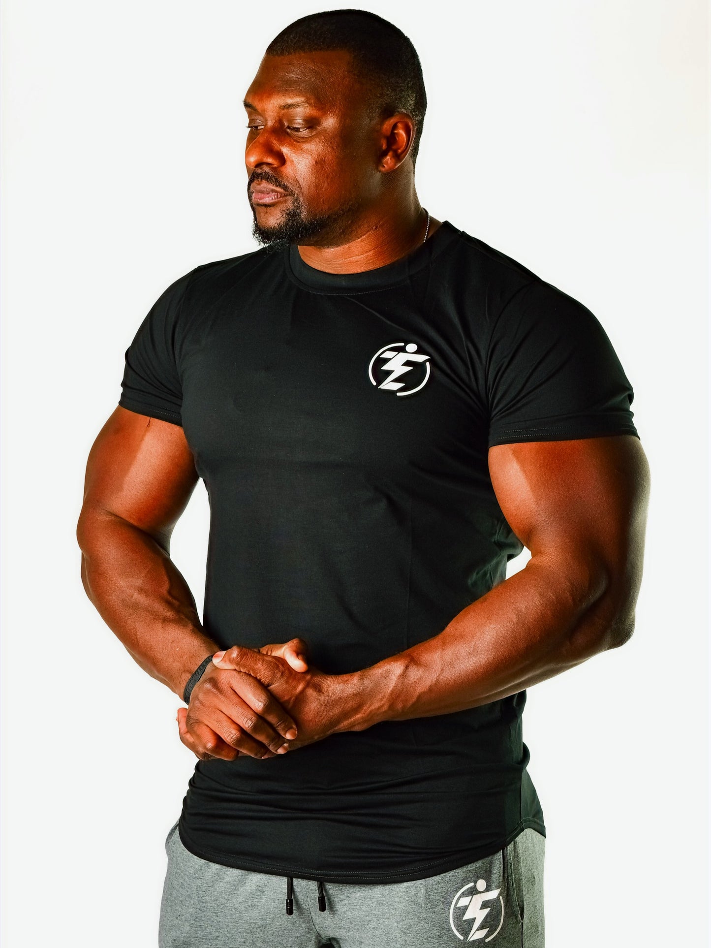 Man in black athletic t-shirt and gray logo shorts. Sportswear set.
