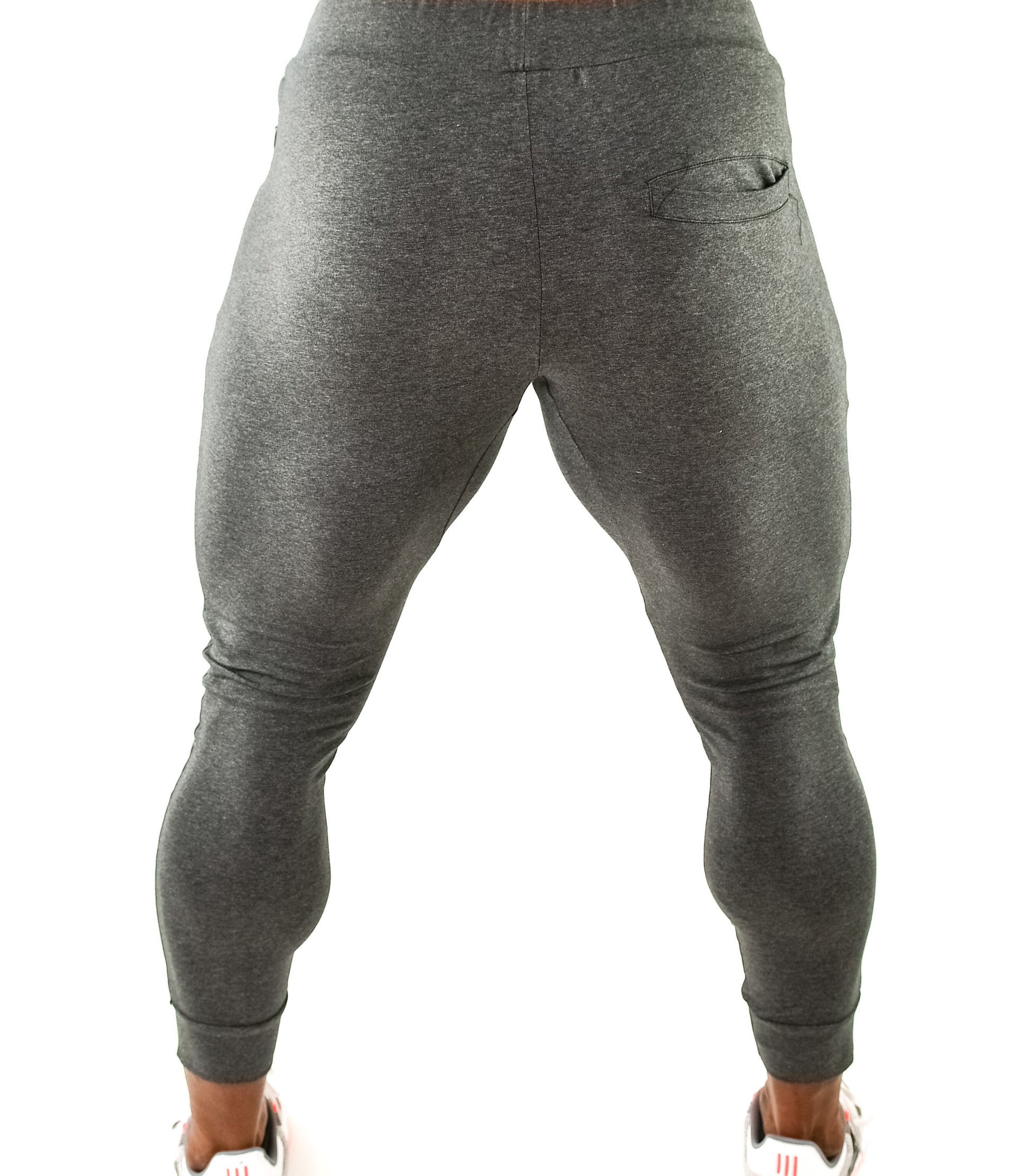 Back view of grey athletic jogger pants on a person, showcasing slim fit and rear pocket.