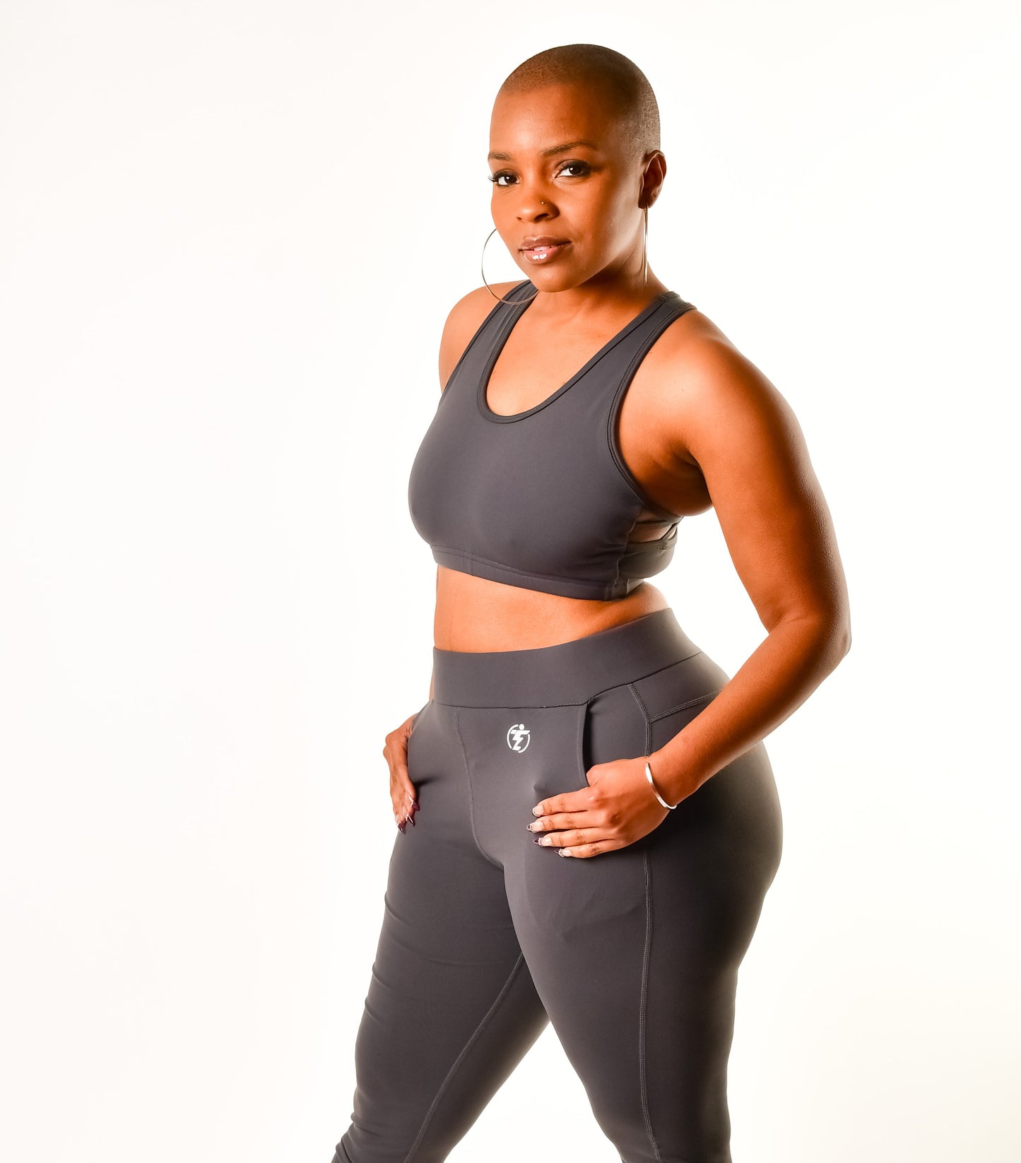 Woman in gray workout set, sports bra and leggings with pockets.