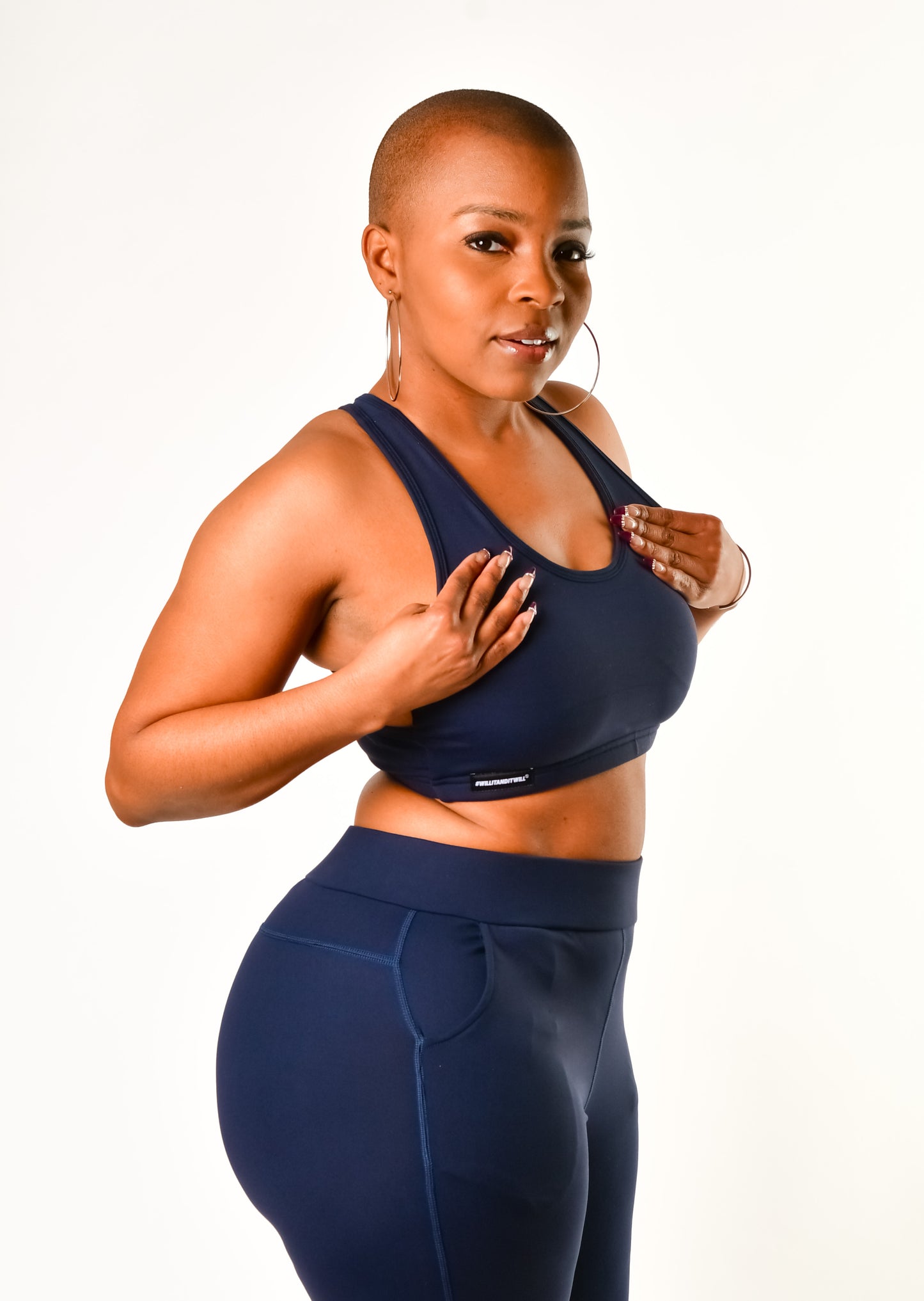 Woman in navy blue sports bra and leggings set.