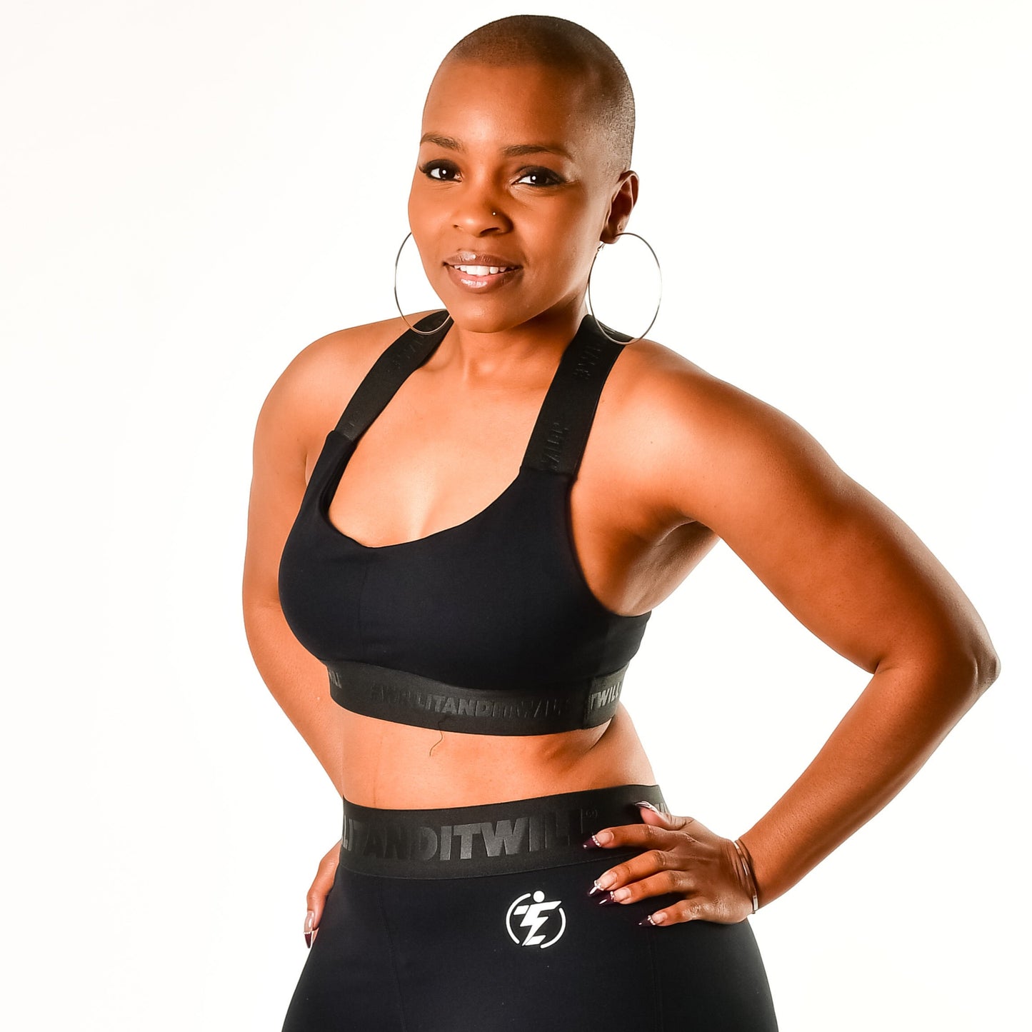 Woman in black sports bra and leggings set with logo. Athletic apparel.