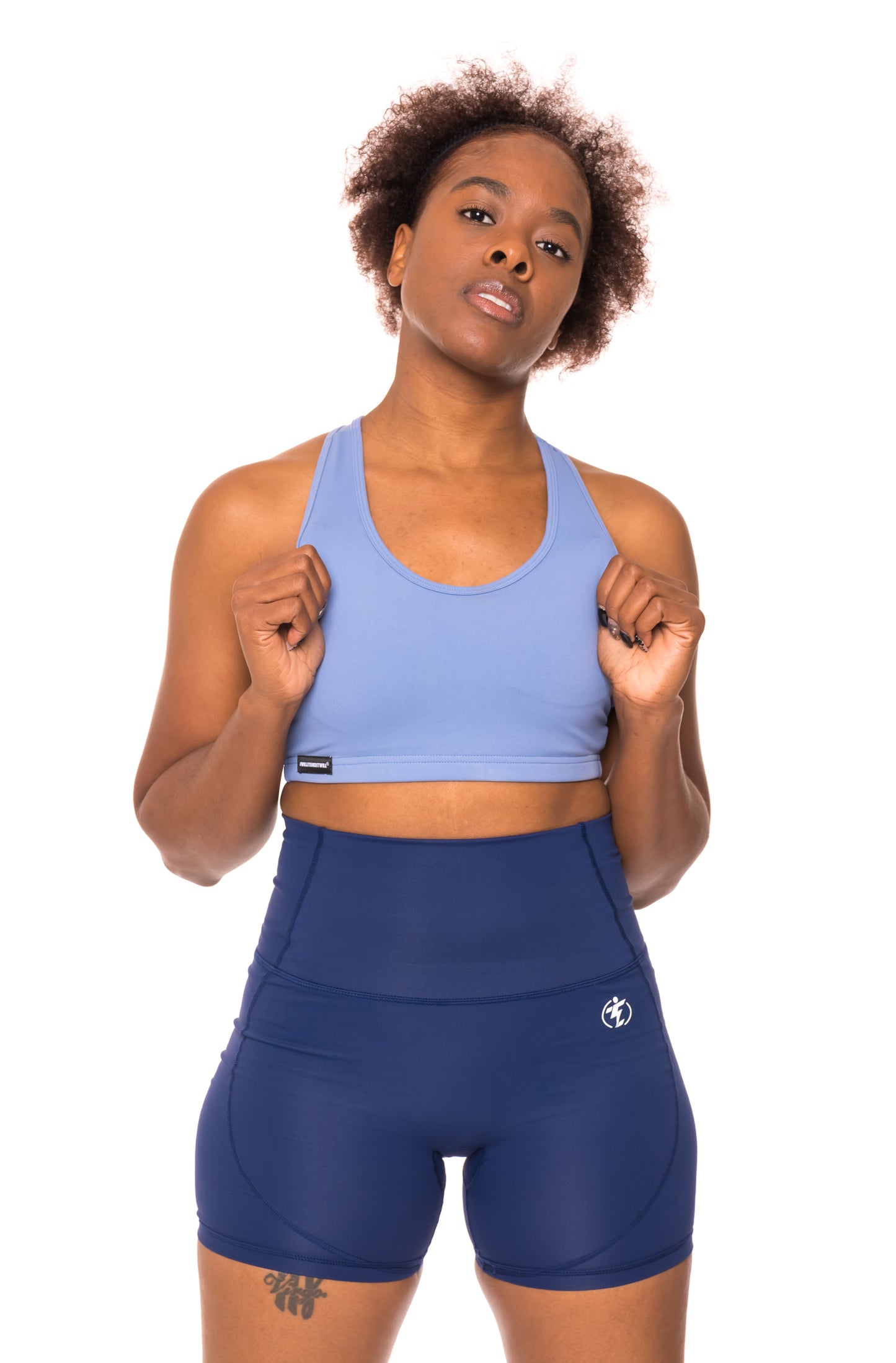 Woman in blue sports bra and high-waisted shorts for athletic performance.