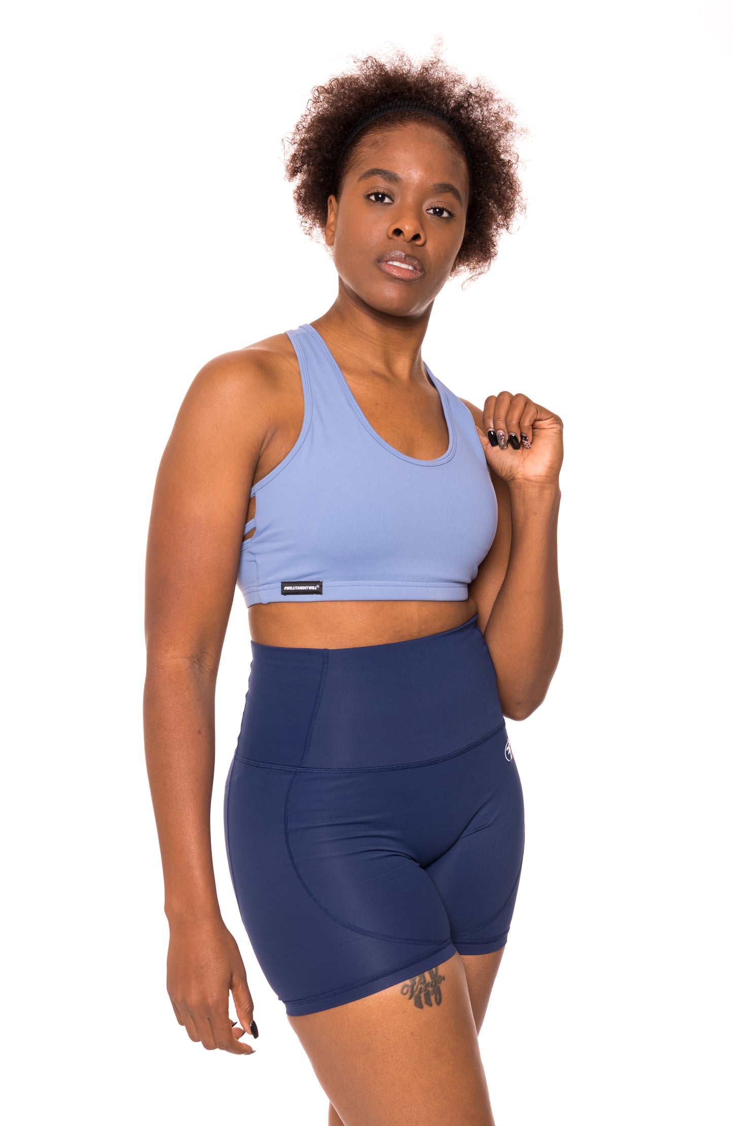 Woman in blue sports bra and shorts workout outfit.