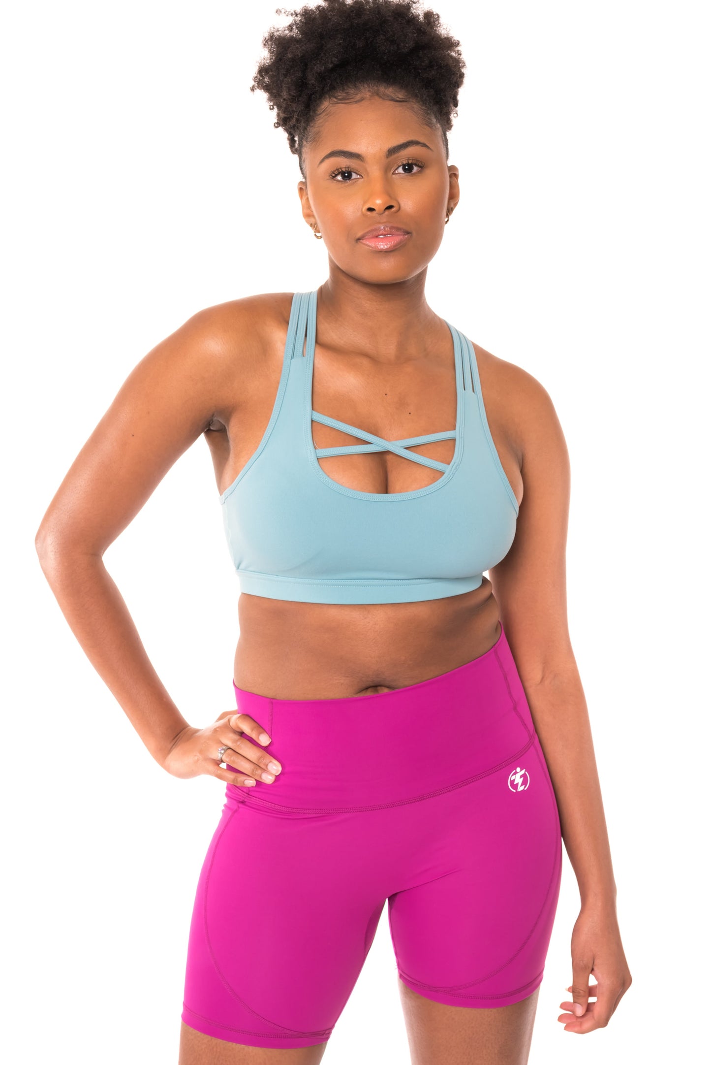 Woman in blue sports bra and pink shorts, activewear outfit.