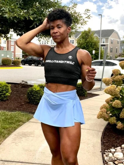 Woman in black tank top and blue skort. Athletic wear outfit.
